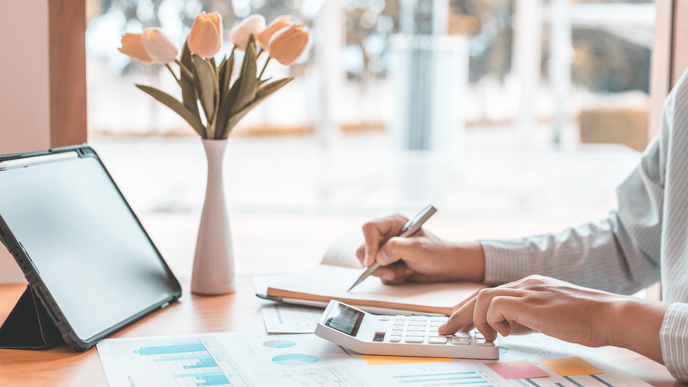 Person reviewing financial documents and using a calculator after filing a tax extension, preparing for extended IRS tax filing deadlines.